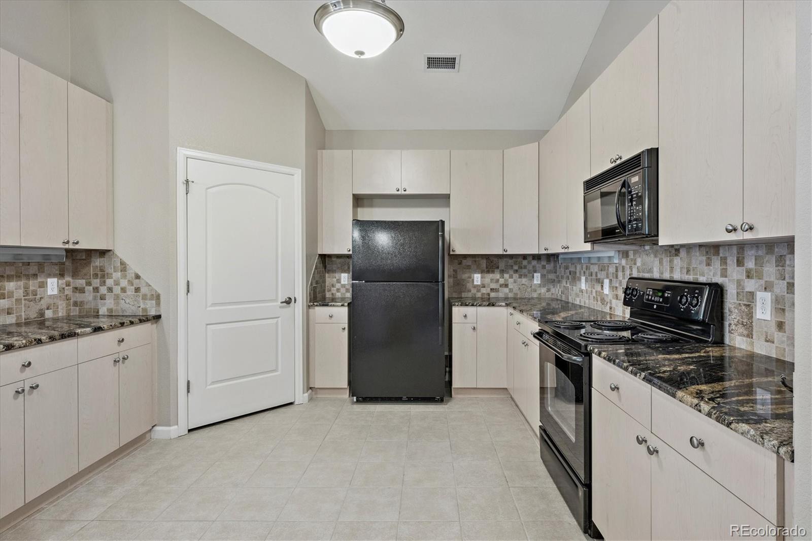 8650 Gold Peak Drive, Unit A Highlands Ranch, CO 80130 - Photo 14 of 47 a kitchen with granite countertop a refrigerator stove and sink
