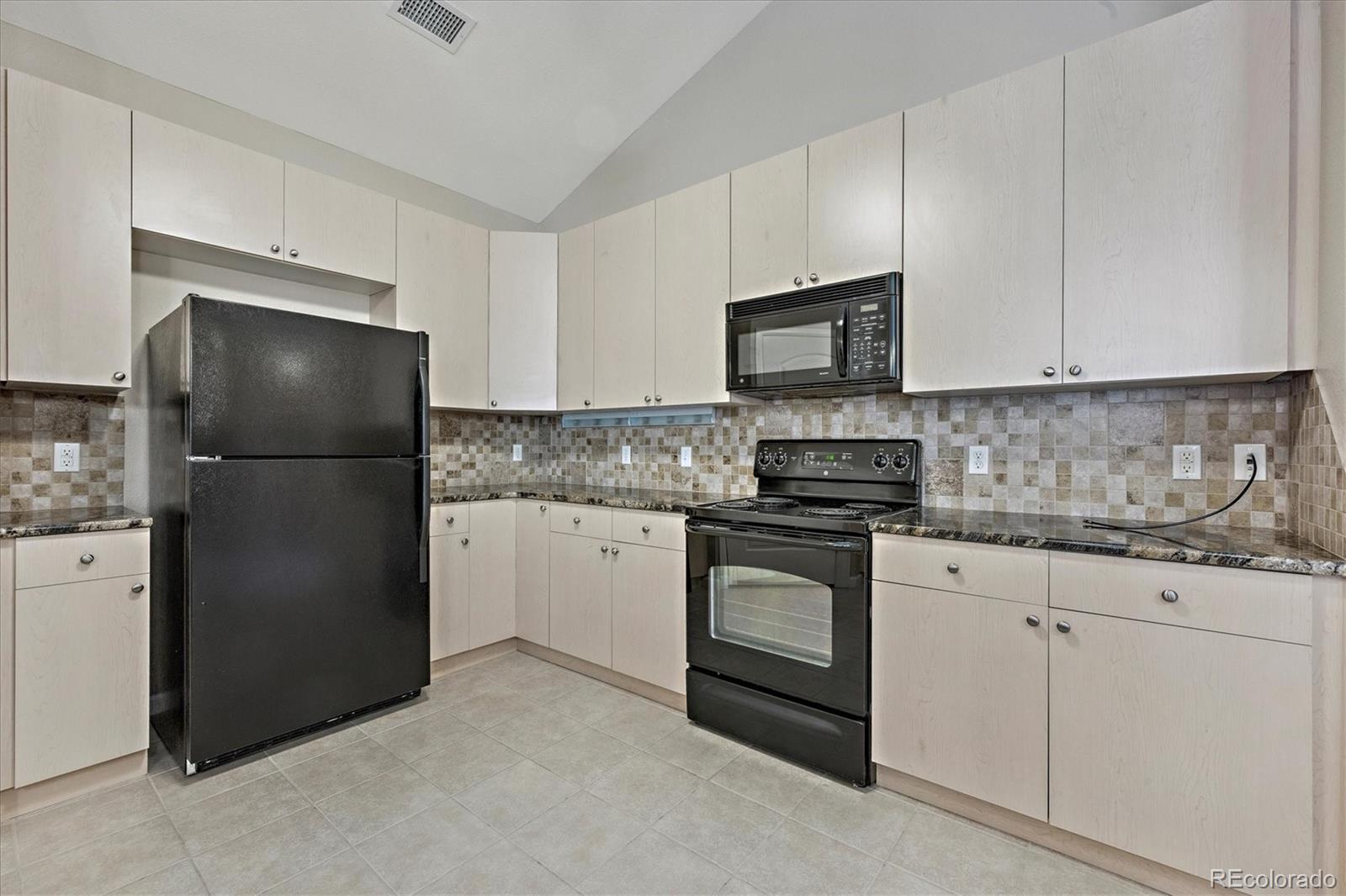8650 Gold Peak Drive, Unit A Highlands Ranch, CO 80130 - Photo 15 of 47 a kitchen with a refrigerator stove and microwave