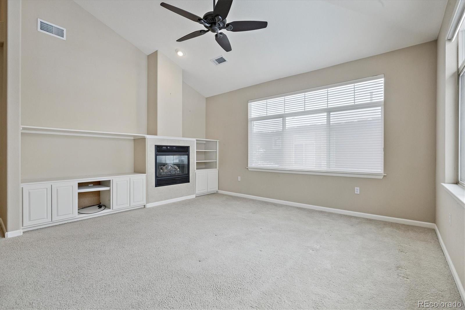 8650 Gold Peak Drive, Unit A Highlands Ranch, CO 80130 - Photo 23 of 47 an empty room with fireplace and windows