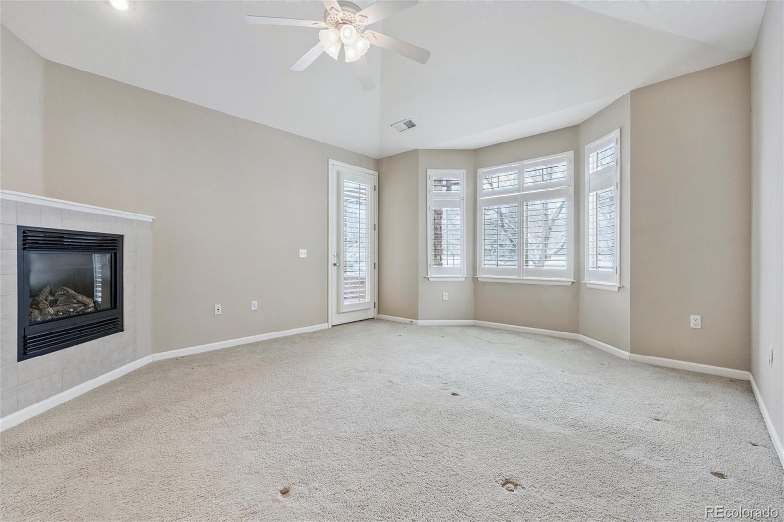 8650 Gold Peak Drive, Unit A Highlands Ranch, CO 80130 - Photo 27 of 47 an empty room with windows and chandelier fan