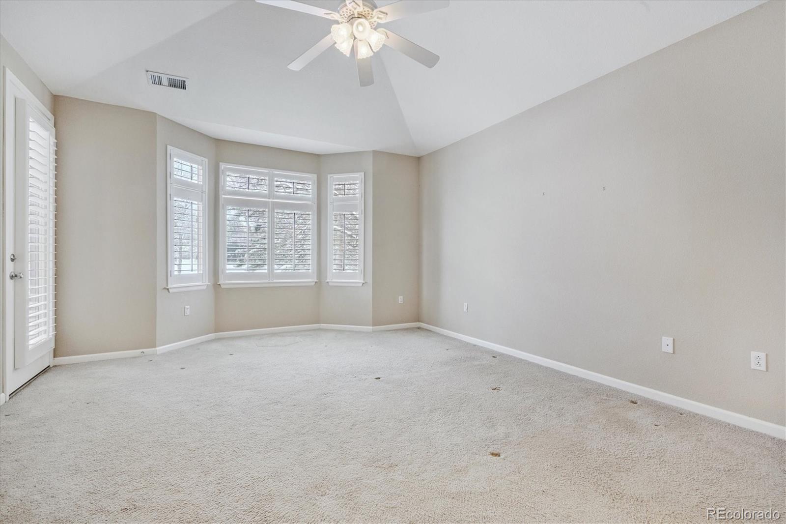 8650 Gold Peak Drive, Unit A Highlands Ranch, CO 80130 - Photo 28 of 47 an empty room with windows and chandelier fan