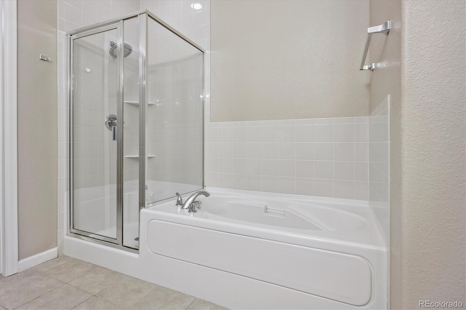 8650 Gold Peak Drive, Unit A Highlands Ranch, CO 80130 - Photo 31 of 47 a bathroom with a bathtub and a shower