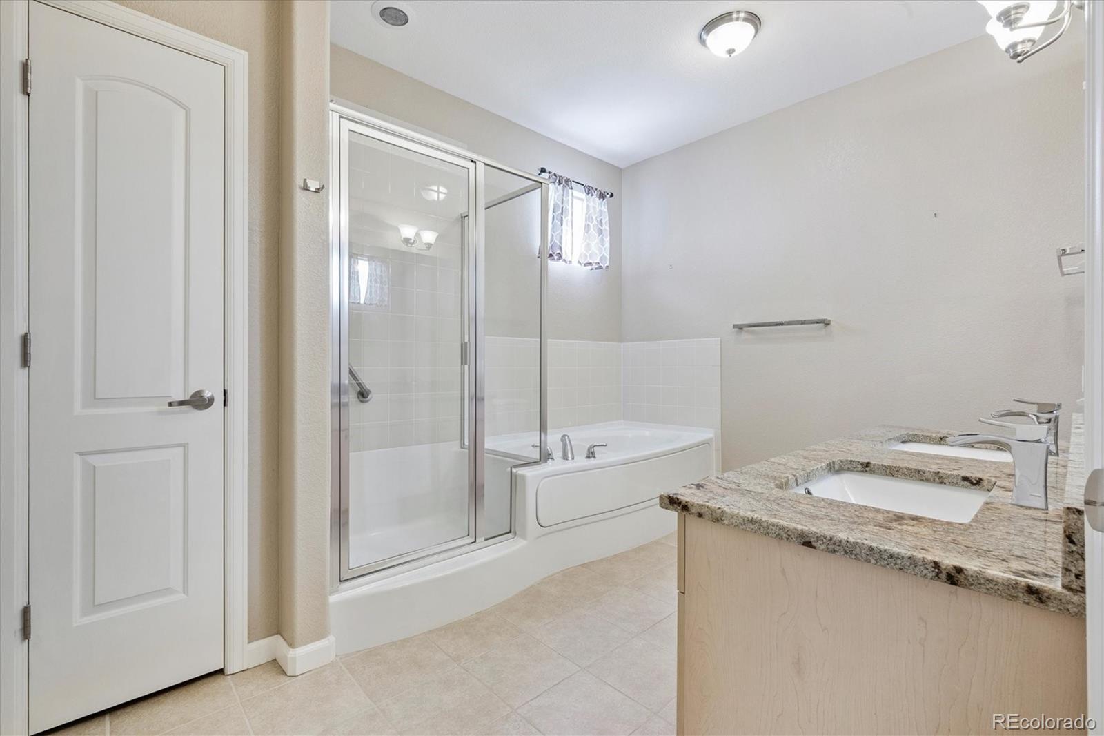 8650 Gold Peak Drive, Unit A Highlands Ranch, CO 80130 - Photo 38 of 47 a bathroom with a granite countertop sink a toilet and shower
