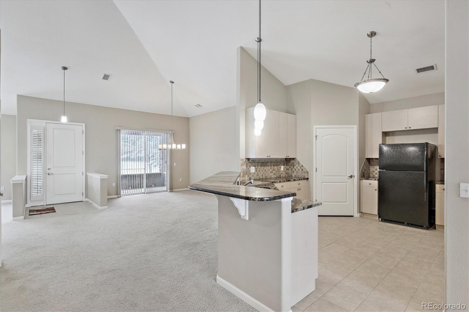 8650 Gold Peak Drive, Unit A Highlands Ranch, CO 80130 - Photo 10 of 47 a kitchen with kitchen island a stove a refrigerator a sink a center island and furniture