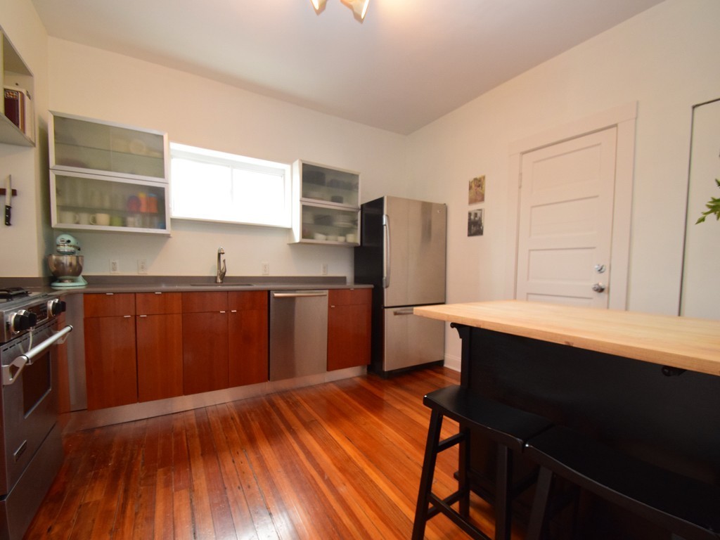 78 Montebello Road, Unit 3 Boston, MA 02130 - Photo 9 of 19 a kitchen with stainless steel appliances wooden floors and wooden cabinets