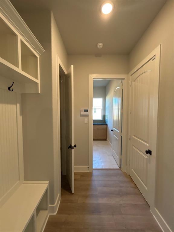 812 Vly Rdg Road Van Alstyne, TX 75495 - Photo 13 of 20 a view of a hallway with wooden floor and a bathroom