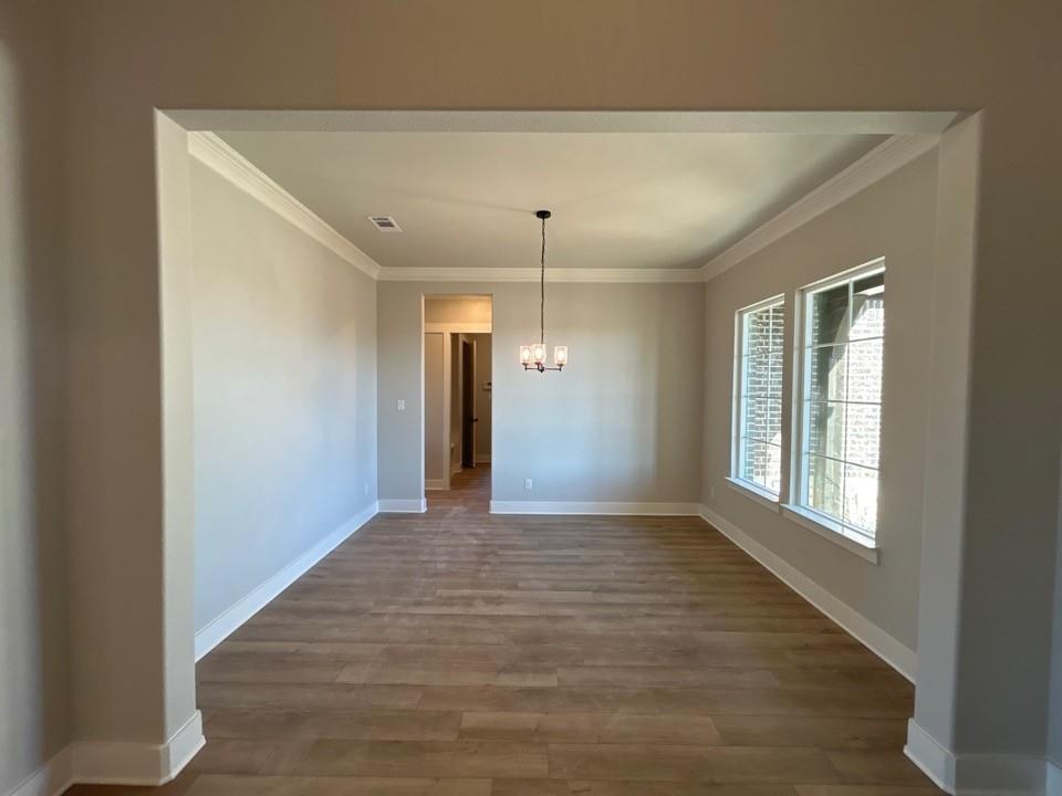 812 Vly Rdg Road Van Alstyne, TX 75495 - Photo 4 of 20 a view of an empty room with wooden floor and a window