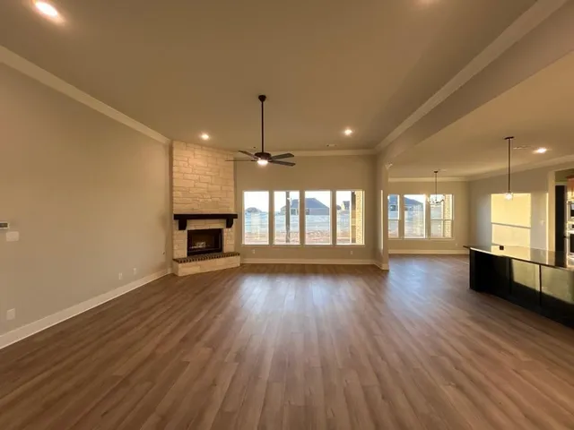 an empty room with wooden floor and fireplace