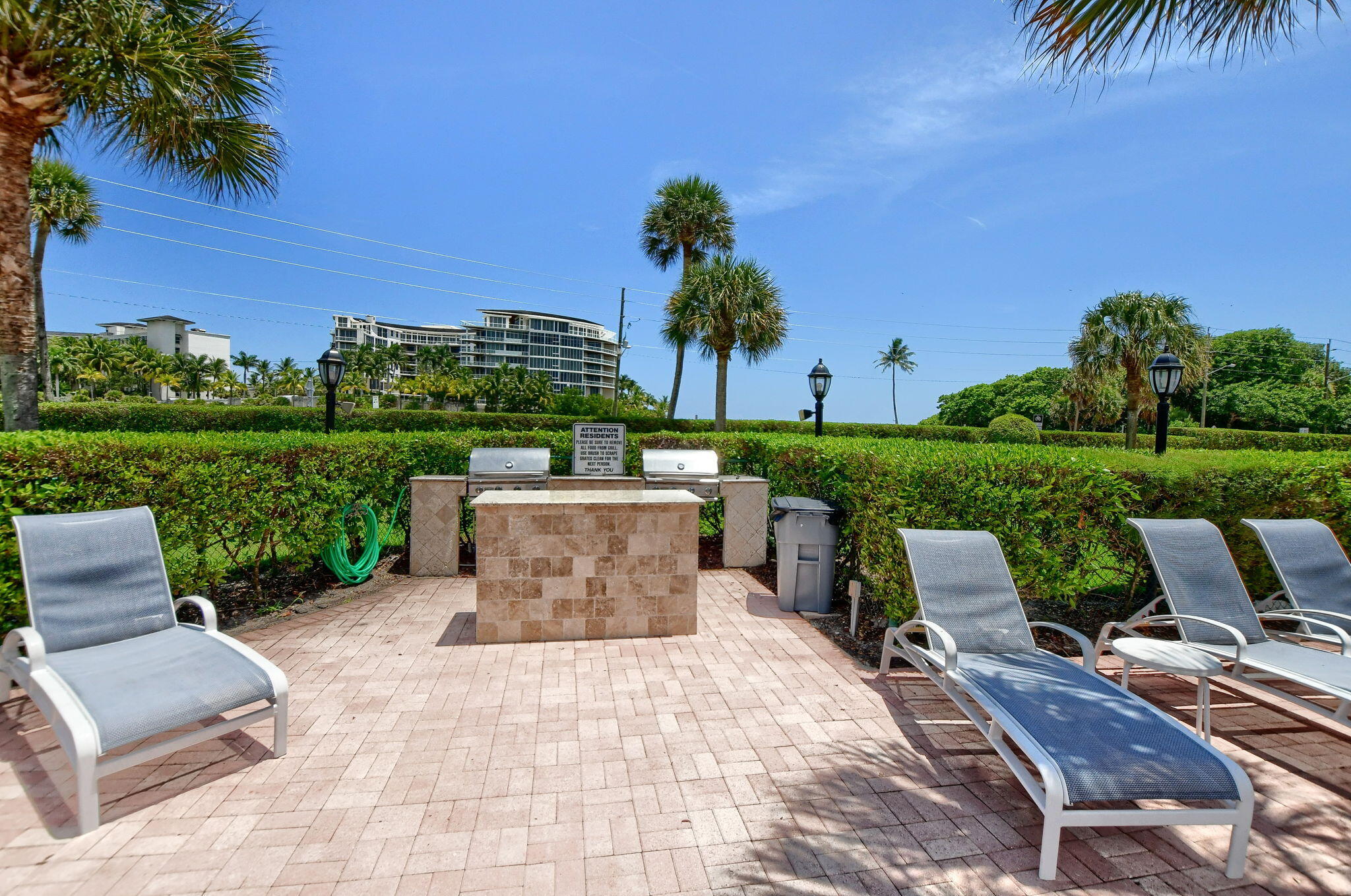1099 South Ocean Boulevard, Unit 105 Boca Raton, FL 33432 - Photo 29 of 30 a view of a patio with table and chairs potted plants and palm tree