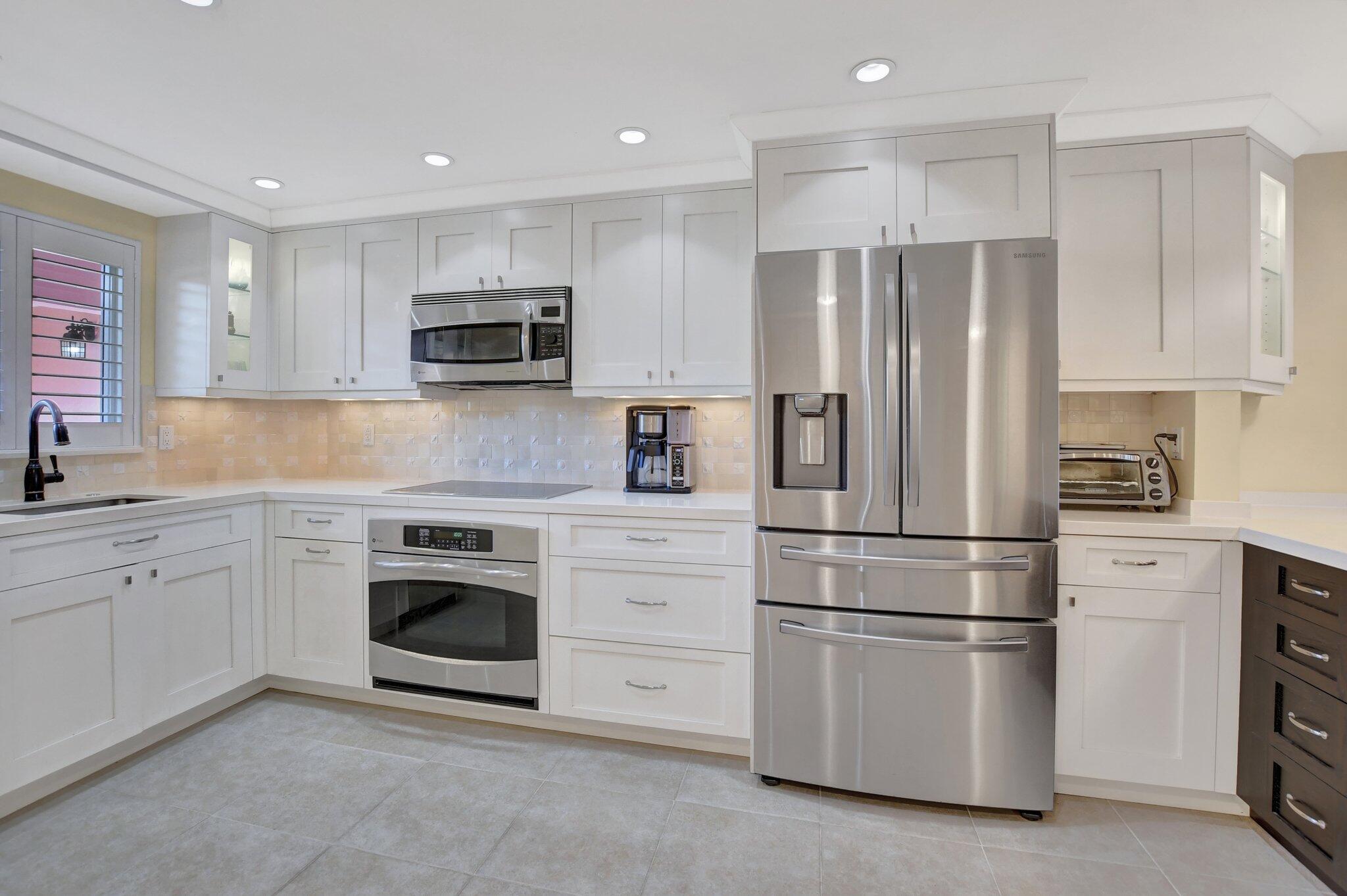 1099 South Ocean Boulevard, Unit 105 Boca Raton, FL 33432 - Photo 6 of 30 a kitchen with cabinets stainless steel appliances and a window