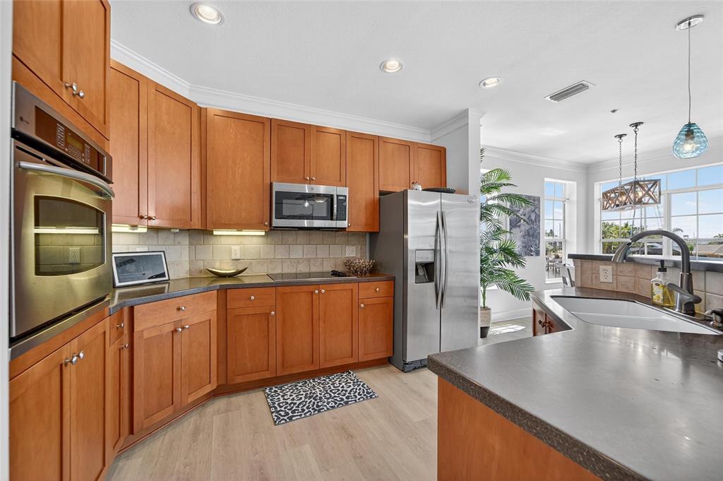 6428 Sunset Bay Circle Apollo Beach, FL 33572 - Photo 24 of 90 a kitchen with stainless steel appliances granite countertop a sink a stove top oven a counter space and cabinets
