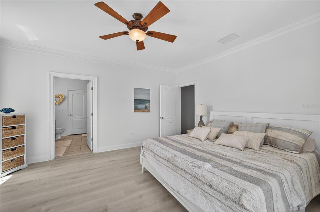 6428 Sunset Bay Circle Apollo Beach, FL 33572 - Photo 35 of 90 a bedroom with a large bed and a chandelier