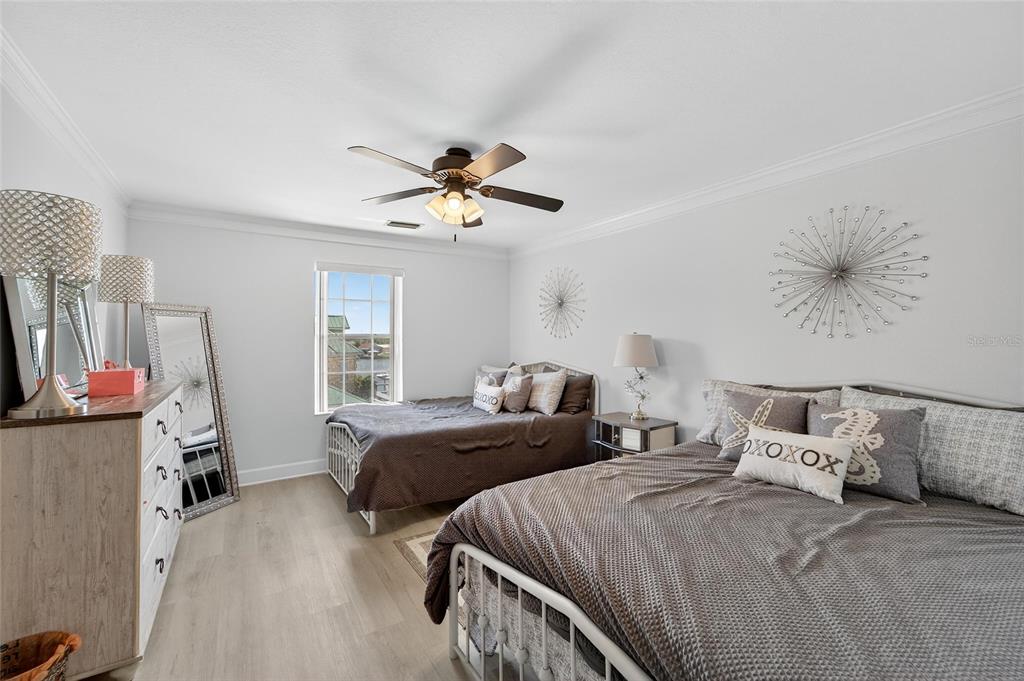 6428 Sunset Bay Circle Apollo Beach, FL 33572 - Photo 46 of 90 a bedroom with two beds and a chandelier