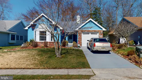 a view of a house with large windows and couches chairs