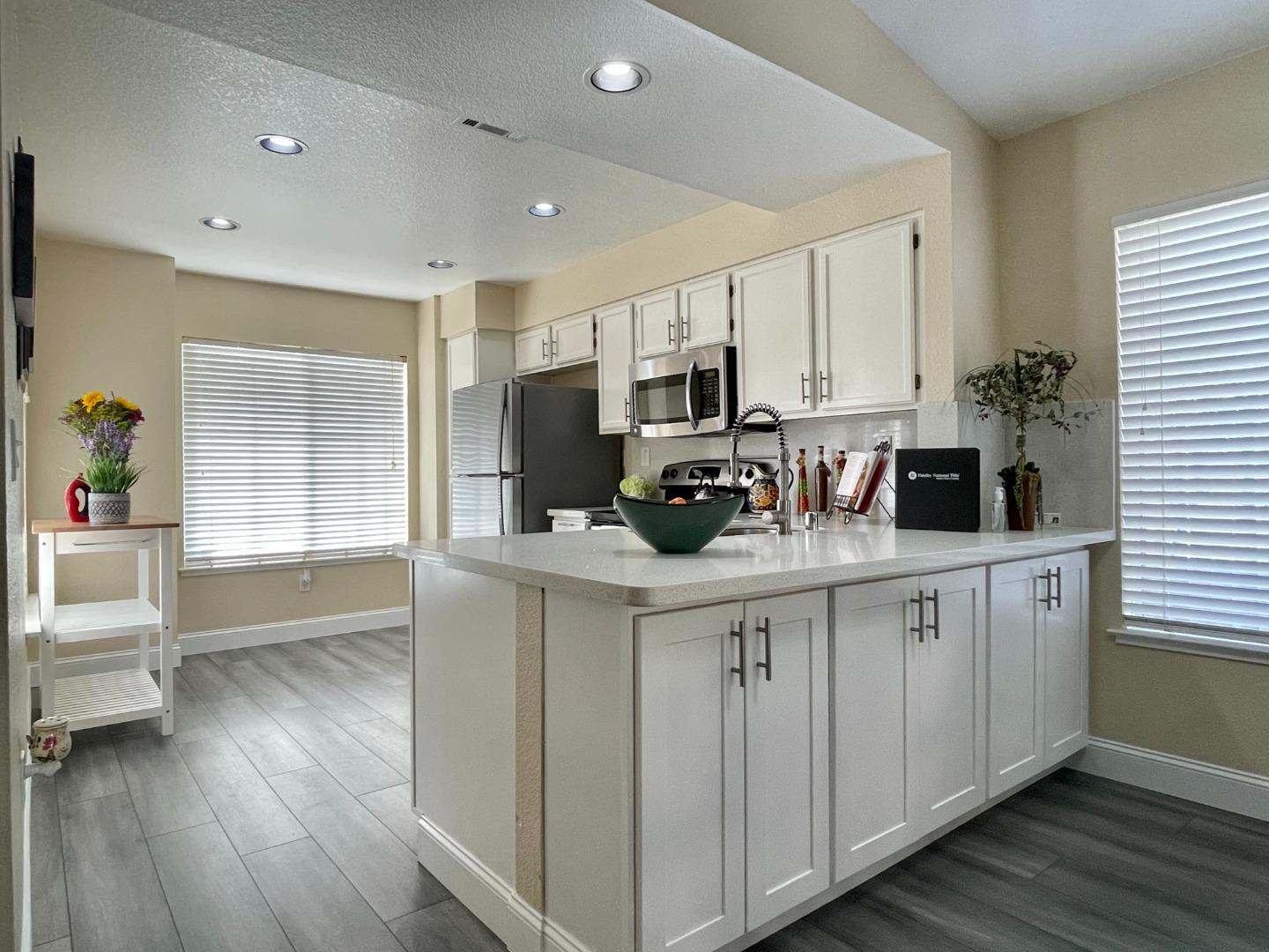 445 Powell Drive Bay Point, CA 94565 - Photo 8 of 43 a kitchen with stainless steel appliances a stove a sink cabinets and a wooden floor