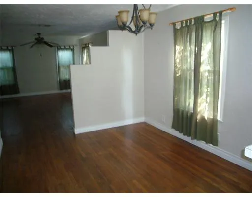 a view of a hallway with wooden floor and windows