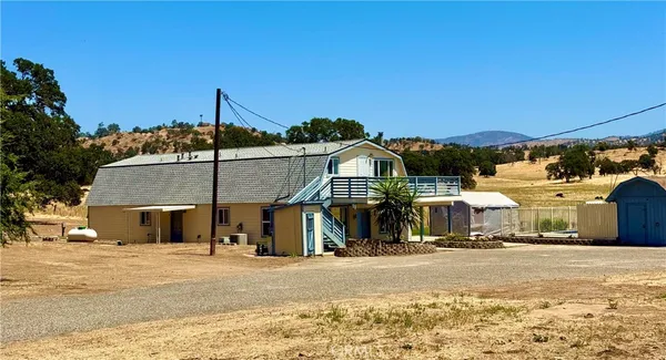 a view of a house with a yard and potted plants