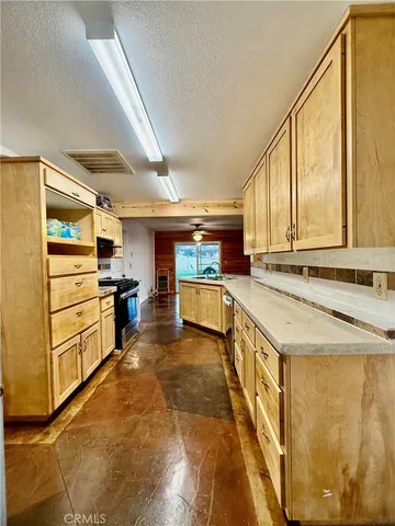 a view of a kitchen with white cabinets and wooden floor