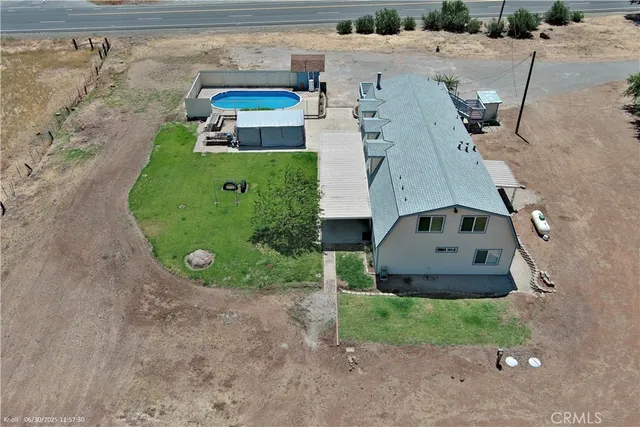 an aerial view of a house with a yard and lake view