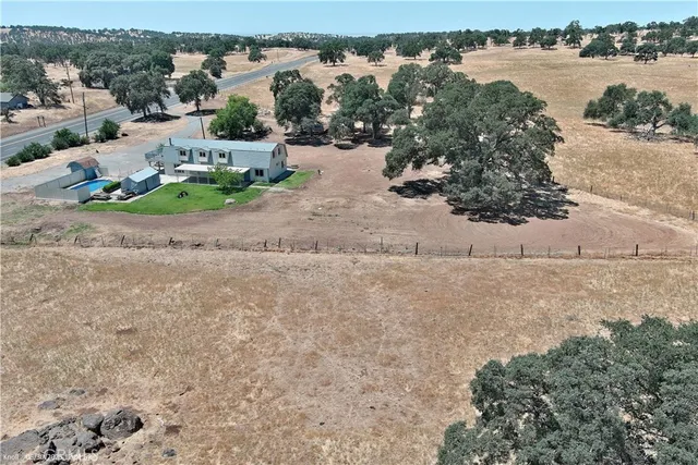an aerial view of a house with a yard and lake view