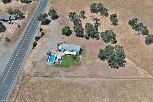an aerial view of a house with a yard and parking spaces
