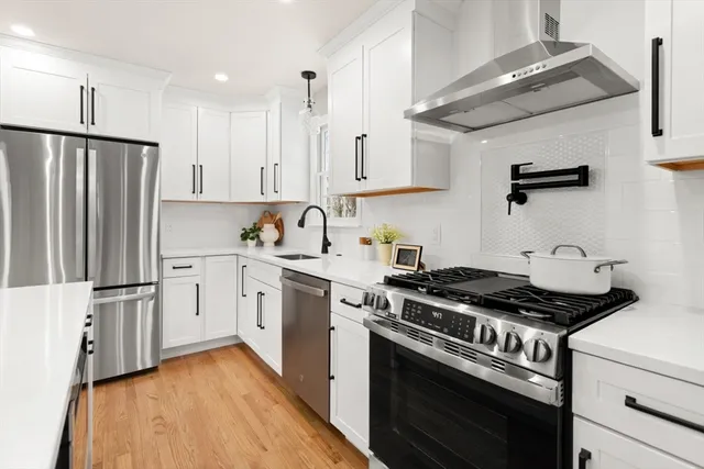 a kitchen with granite countertop a sink stove and refrigerator