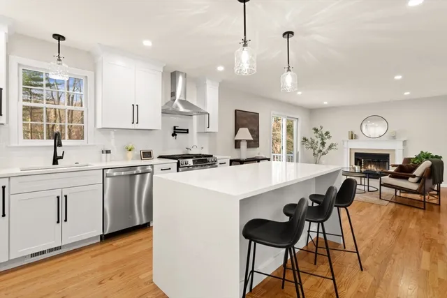a kitchen that has a lot of cabinets furniture appliances and wooden floor