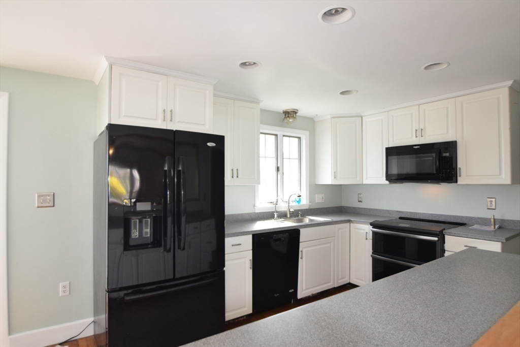 71 Rockefeller Street Randolph, MA 02368 - Photo 2 of 23 a kitchen with a sink stainless steel appliances and cabinets