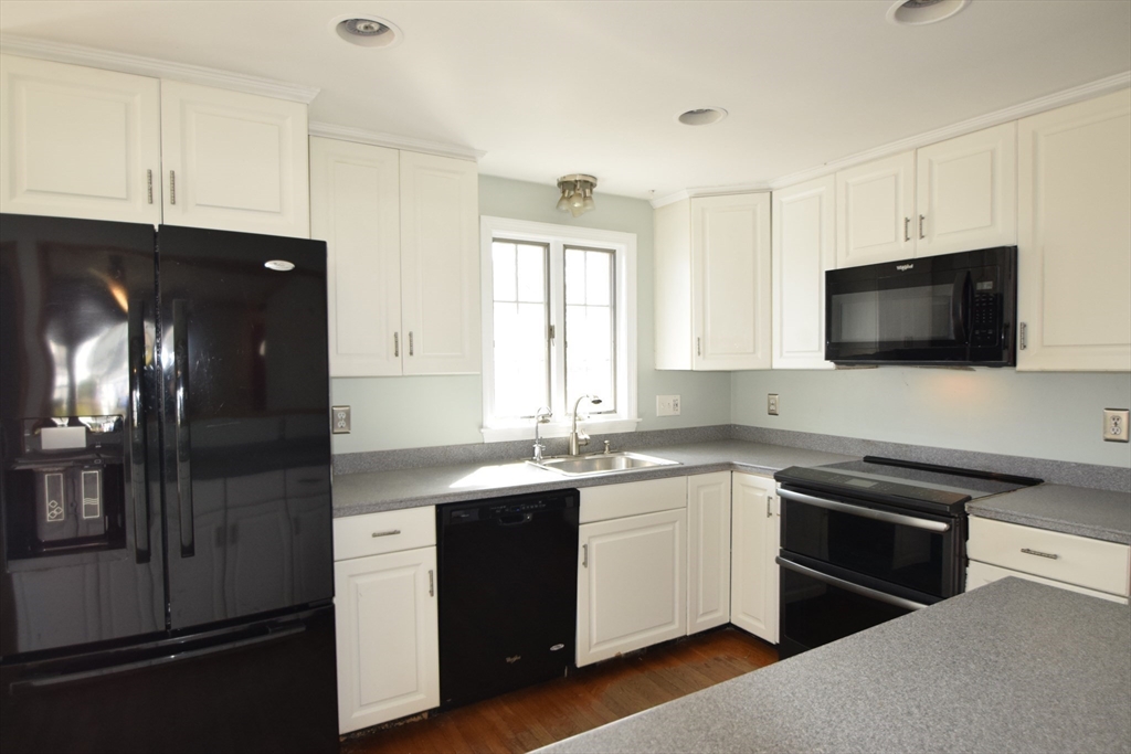 71 Rockefeller Street Randolph, MA 02368 - Photo 3 of 23 a kitchen with a sink stainless steel appliances and cabinets
