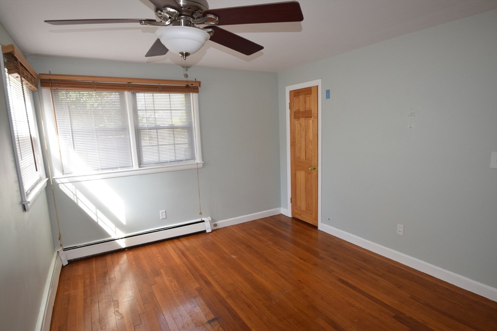 71 Rockefeller Street Randolph, MA 02368 - Photo 8 of 23 an empty room with wooden floor fan and windows