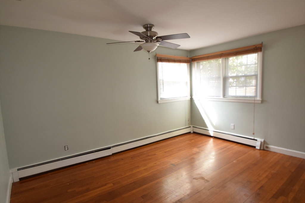 71 Rockefeller Street Randolph, MA 02368 - Photo 9 of 23 an empty room with wooden floor fan and windows