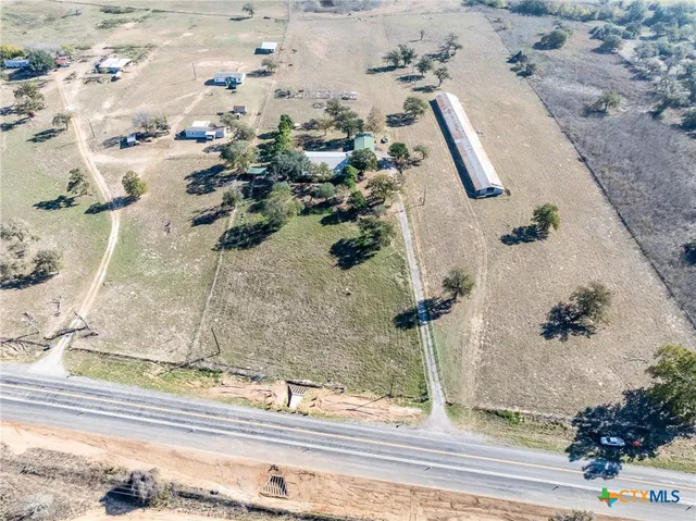 a view of a pathway both side of grassy field with shrub