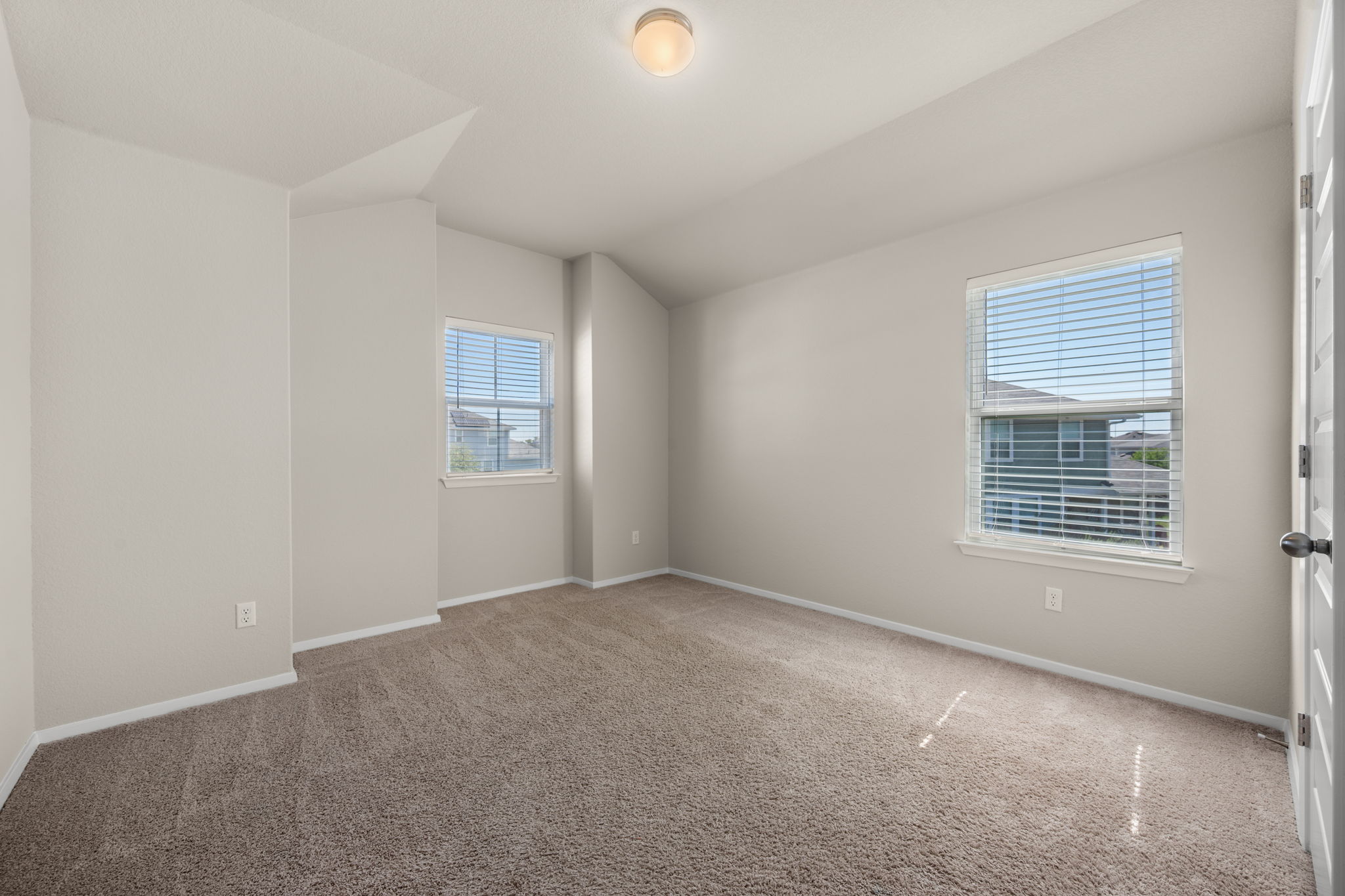 215 Lake Placid Run Elgin, TX 78621 - Photo 20 of 29 Plush carpeting and neutral-toned walls define this versatile bedroom space with dual windows.