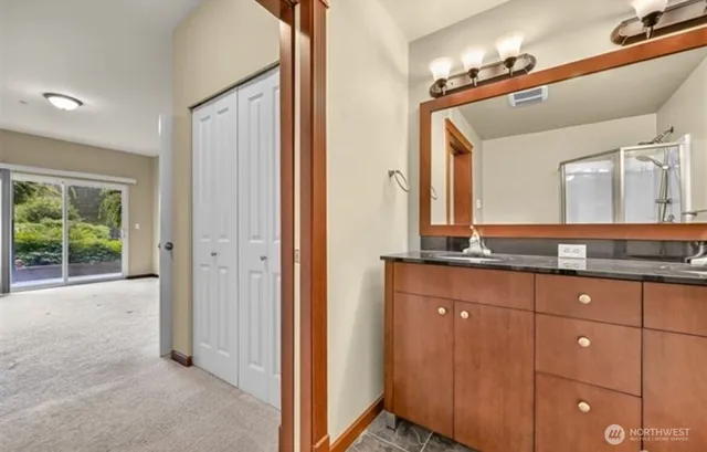 a bathroom with a granite countertop sink and a mirror