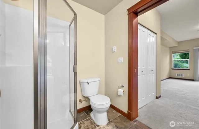 a bathroom with a toilet and a shower