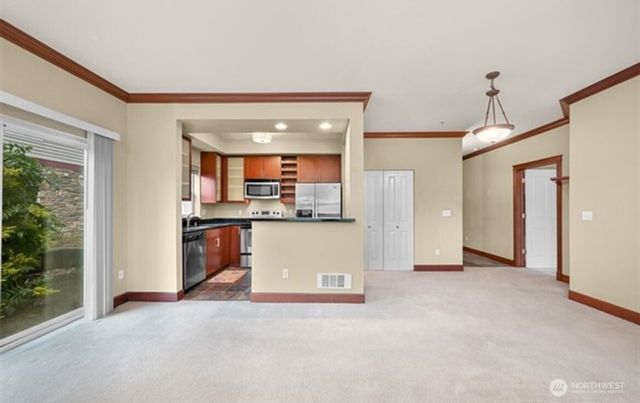 a view of kitchen with stainless steel appliances granite countertop cabinets and outdoor view