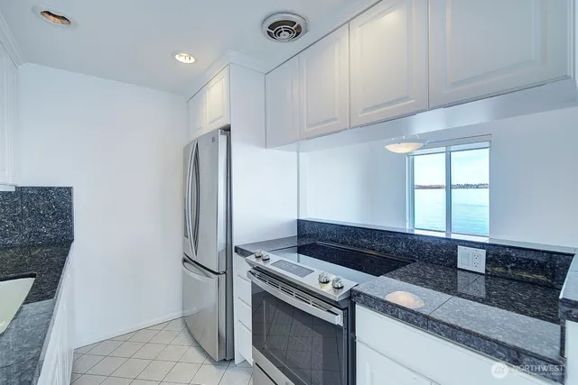 a kitchen with granite countertop a refrigerator and a stove