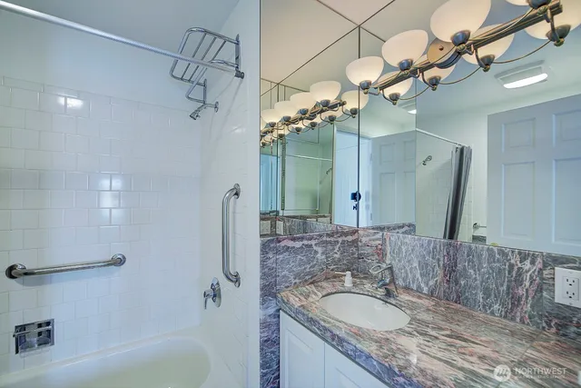a bathroom with a granite countertop sink a toilet and shower
