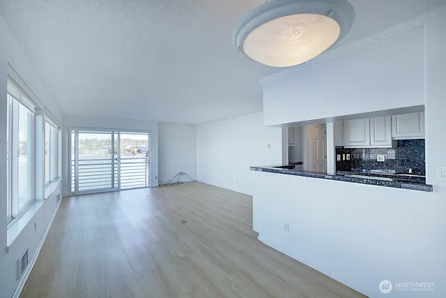 an empty room with wooden floor and a large window