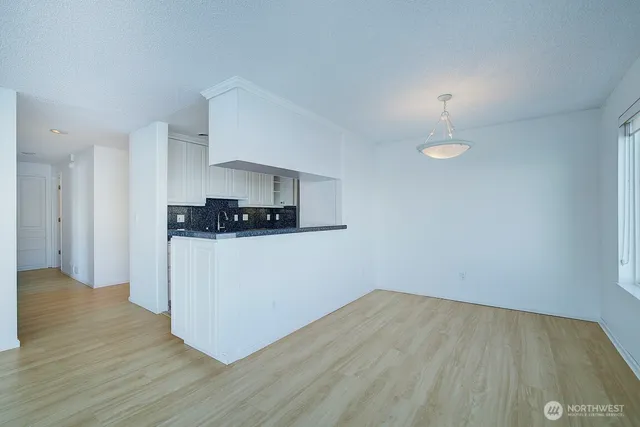 a view of a kitchen with wooden floor and electronic appliances