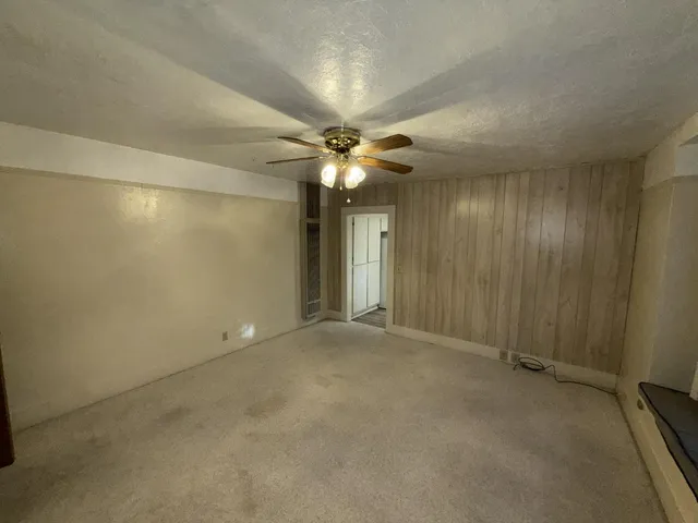 an empty room with a ceiling fan and a shower