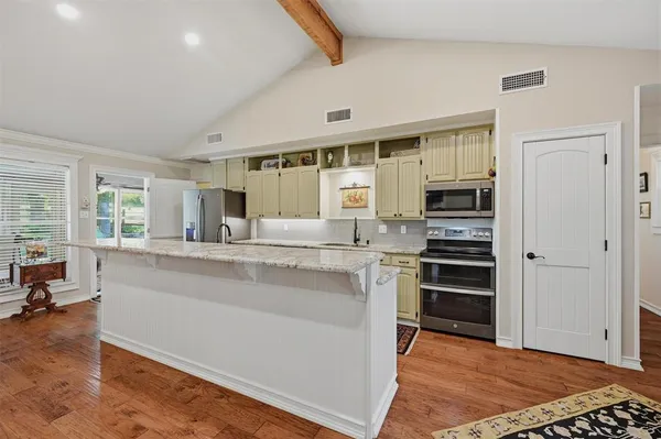 a kitchen with stainless steel appliances granite countertop a stove and a refrigerator
