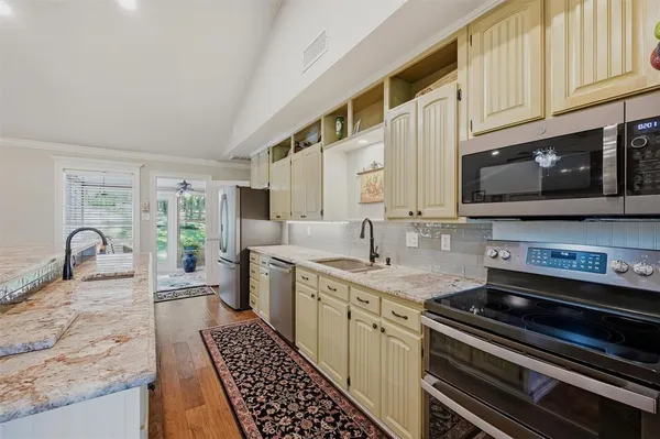 a kitchen with stainless steel appliances granite countertop a stove a sink and a microwave