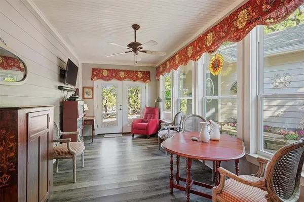 a living room with furniture large window and wooden floor