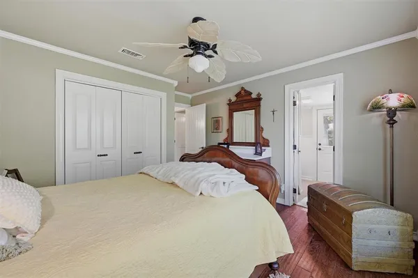 a bedroom with a bed couches and ceiling fan