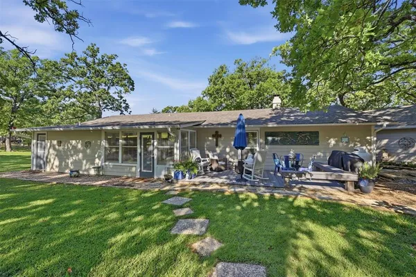 a front view of a house with garden and sitting area