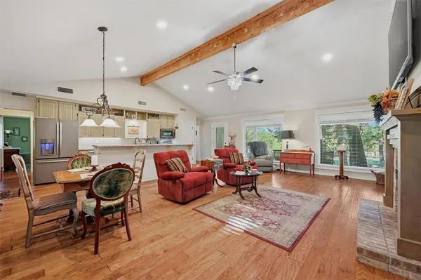 a living room with furniture a window and wooden floor