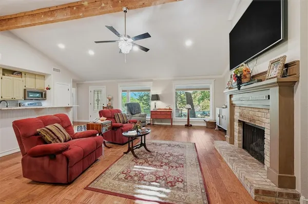 a living room with furniture a fireplace and a flat screen tv