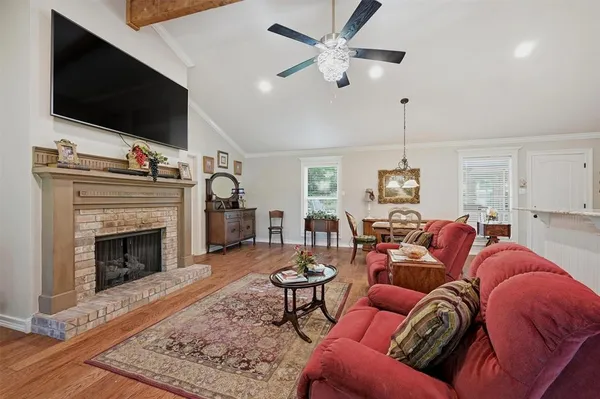 a living room with furniture a flat screen tv and a fireplace