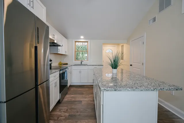 a kitchen with stainless steel appliances granite countertop a refrigerator sink and cabinets